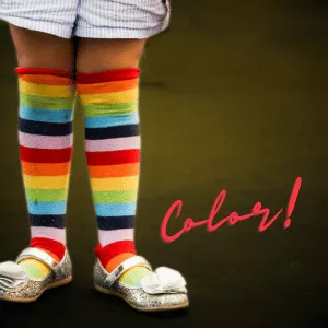 Kid with colorful sock above knees with the word 'color'